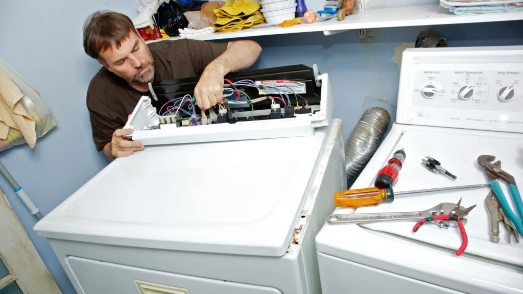 Person inspecting an open dryer control console