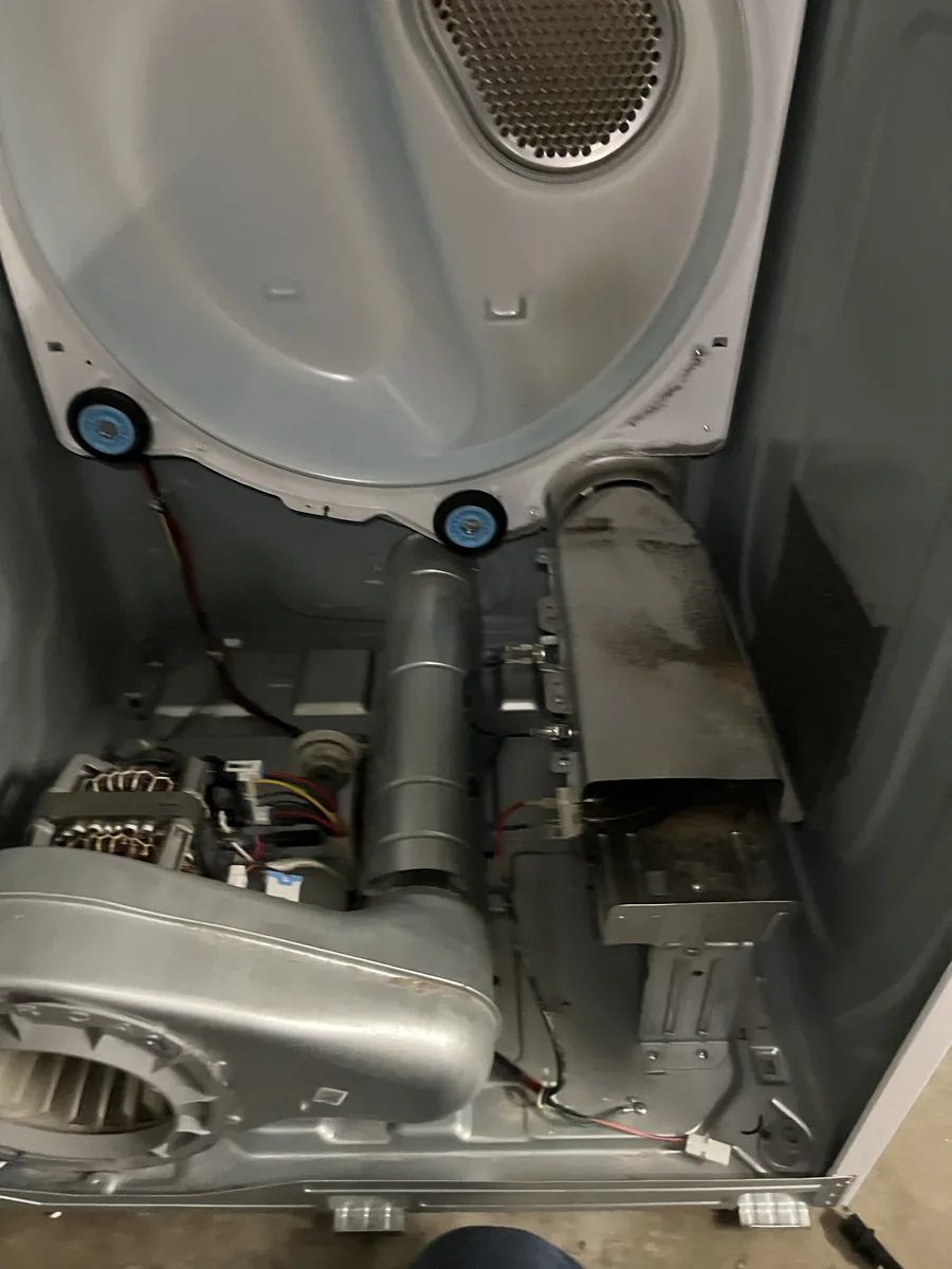 Opened dryer showing its motor, blower housing and drum-support components