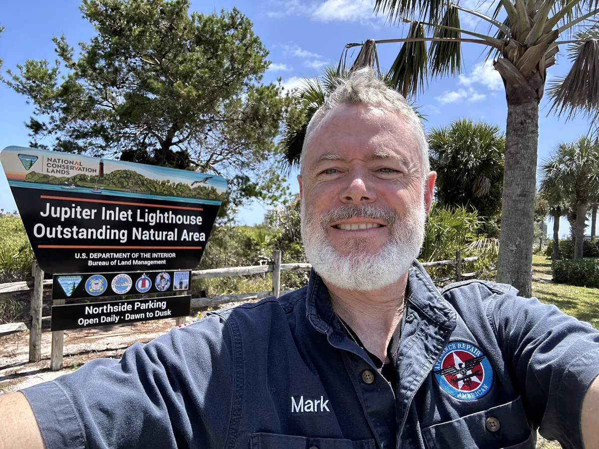 Mark Oliver beside the Jupiter Inlet Lighthouse Outstanding Natural Area sign.